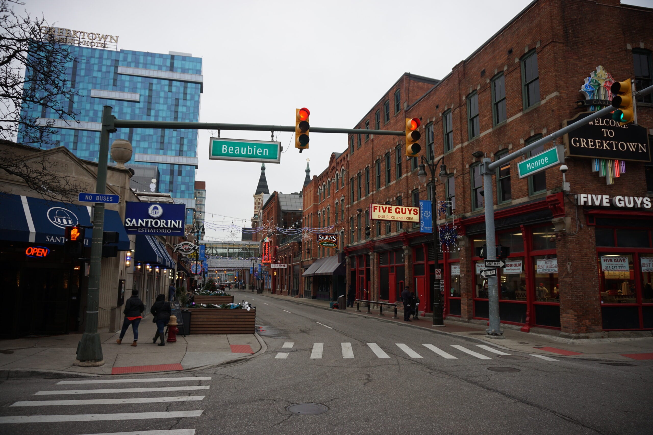 Intersection in Greektown Detroit with brick storefronts, traffic lights, and street signs Beaubien and Monroe on a cloudy day