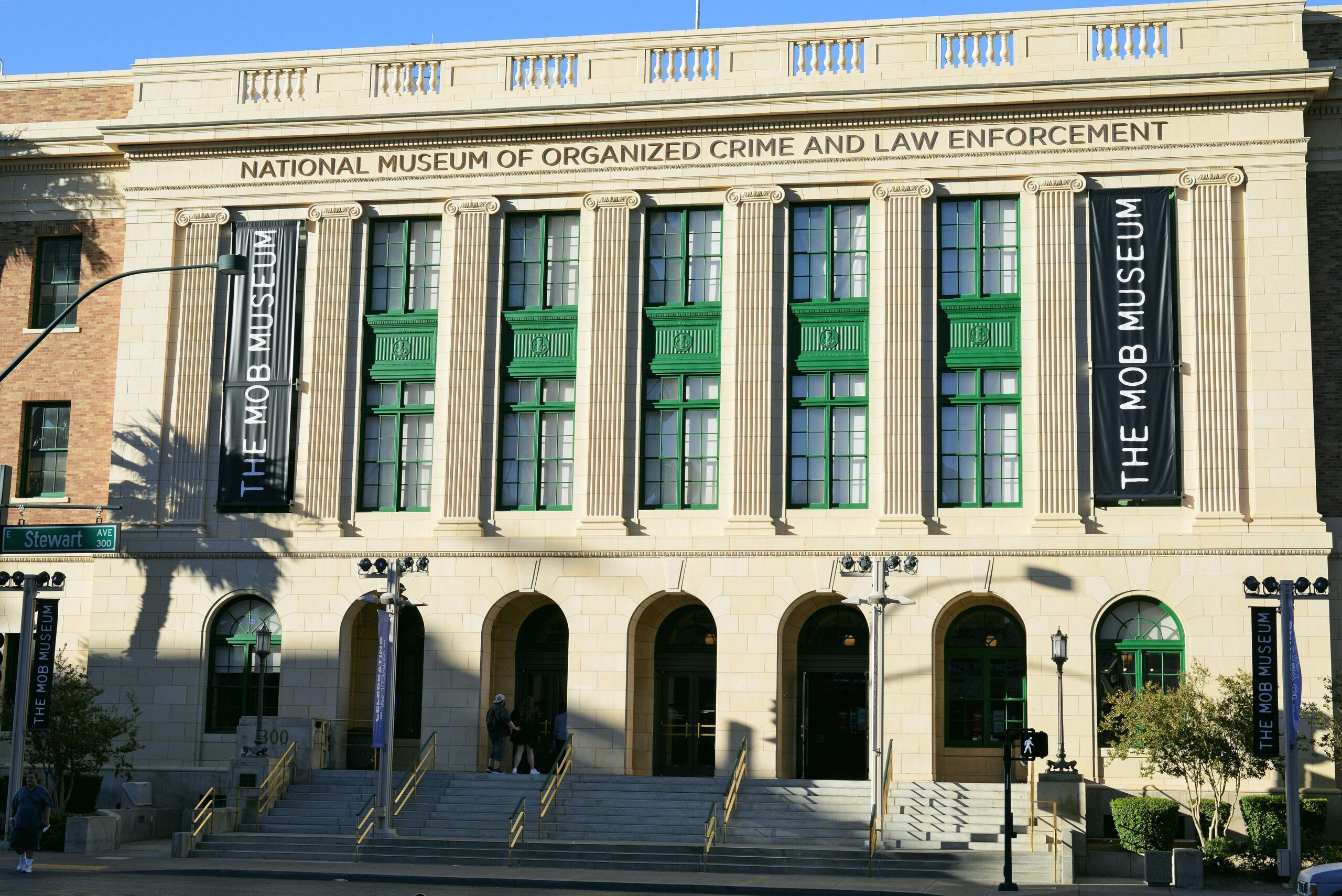 Facade of The Mob Museum building with banners, stone columns, and green-framed windows; people on the steps.